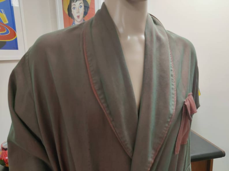 May include: A green and pink silk robe with a shawl collar and a tie at the waist. The robe has a pink satin trim.