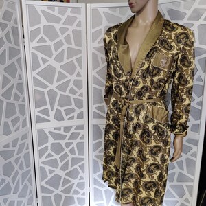 May include: A gold and brown paisley patterned robe with a satin collar and matching tie. The robe has a single pocket on the left side.