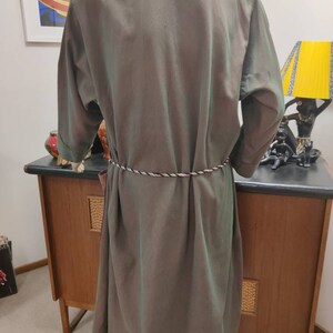 May include: A long, green, silky robe with a white rope belt. The robe has a collar and long sleeves.