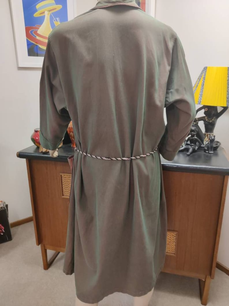 May include: A long, green, silky robe with a white rope belt. The robe has a collar and long sleeves.