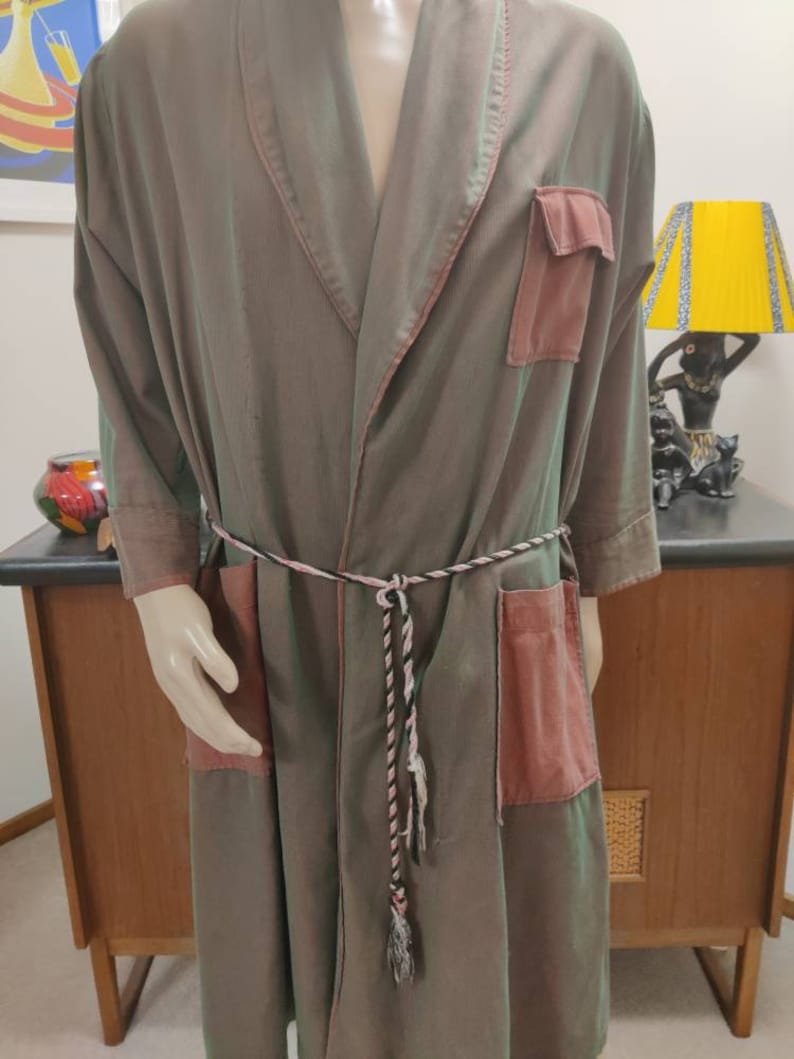 May include: A long, green and pink robe with a braided belt and two patch pockets. The robe is made of a soft, silky fabric.