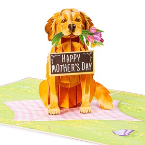 May include: A golden retriever dog-shaped pop-up card holding a sign that reads "HAPPY MOTHER'S DAY." The dog is also holding a bouquet of pink and purple tulips. The card is on a picnic blanket with a butterfly.
