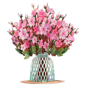 May include: A 3D pop-up card featuring a bouquet of pink cherry blossoms in a light blue vase. The card has intricate details, with layers of paper creating a realistic floral arrangement. The vase sits on a round, orange-toned base.