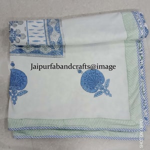 May include: White cotton bed sheet with a blue and green floral print. The sheet has a green and white striped border. The text "Jaipurfabandcrafts@image" is printed on the sheet.