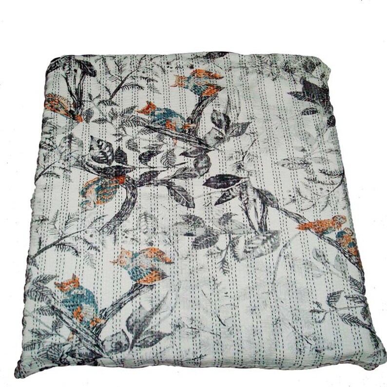 May include: A white kantha quilt with a black and gray floral pattern and orange and blue birds. The quilt has a striped pattern.