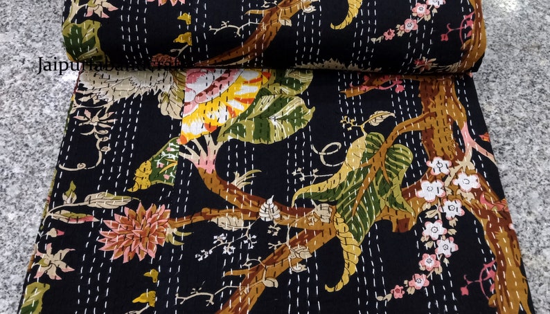 May include: Black kantha quilt with a floral pattern featuring white stitching. The quilt has a dark background with a variety of flowers and leaves in shades of pink, yellow, green, and brown.