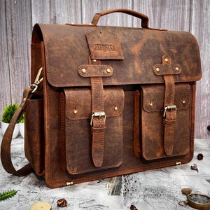 Angled front-left view showing handle, strap, and engraved name "SVJ" on leather flap
