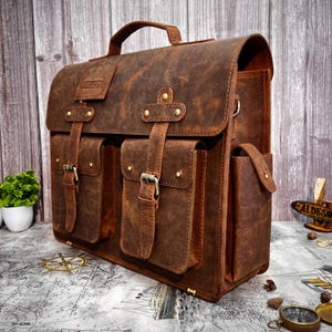 Angled back-right view of the leather satchel with reinforced stitching and metal hardware