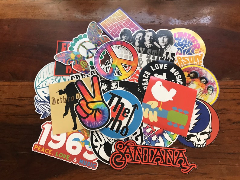 May include: A collection of colourful vintage stickers featuring peace signs, band logos, and 1960s-inspired designs. The stickers include the words "Peace Love Music", "The Who", "Jethro Tull", "1969", and "Santana".