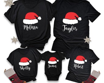 Pode incluir: T-shirts pretas com um design de chapéu de Papai Noel vermelho e nomes personalizados: Melissa, Taylor, Shelly, James e Robert. Roupas de Natal festivas para reuniões familiares. Inclui decorações de flocos de neve e meias.