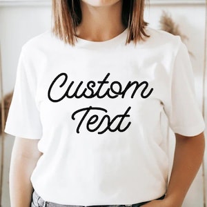 Peut inclure: T-shirt blanc avec du texte noir en écriture cursive qui dit "Custom Text".