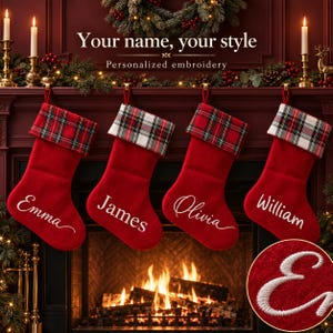 May include: Four red Christmas stockings with plaid cuffs hanging from a mantel. Each stocking features white embroidered names: Emma, James, Olivia, and William. A circular inset shows a close-up of the white embroidered letter E.