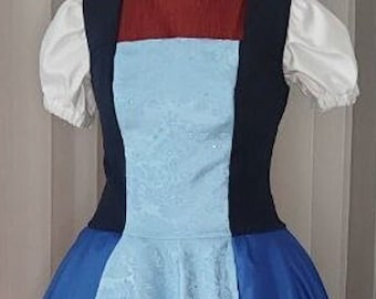 May include: A blue and white dress displayed on a mannequin. The dress features a dark blue bodice with a light blue panel and a white lace overlay. The skirt is a darker shade of blue, creating a layered effect. The dress has short, puffy white sleeves.