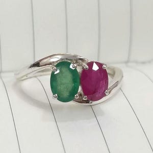 Peut inclure: Une bague en argent avec une émeraude ovale verte et un rubis ovale rouge.