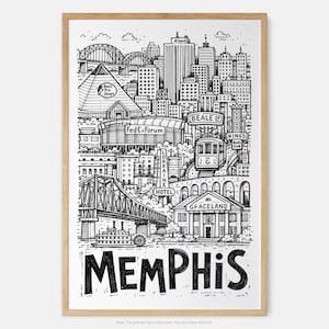 May include: A black and white line art print of the Memphis skyline in a light wood frame. The illustration features landmarks like the Bass Pro Shops pyramid, FedExForum, Beale Street, the Lorraine Hotel, and Graceland, with the word MEMPHIS below.