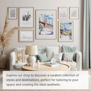 May include: A collection of framed art prints featuring cityscapes, including the Empire State Building, Brooklyn Bridge, and Seattle. The prints are displayed above a sofa with decorative pillows and a round coffee table. The overall aesthetic is modern and stylish.