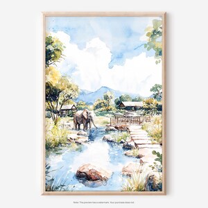 May include: Watercolor painting of an elephant drinking from a river in a natural landscape. The artwork features a wooden bridge, stone path, and lush greenery under a blue sky with clouds. The painting is framed in a light wood.