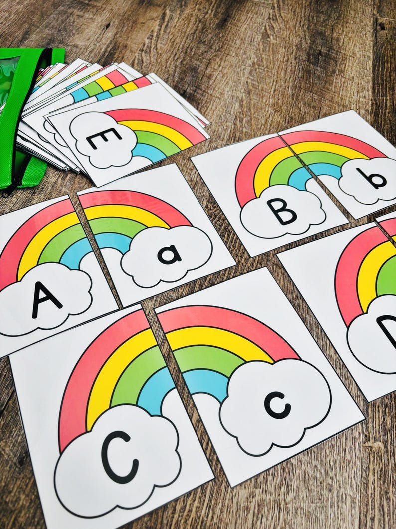 May include: Educational rainbow puzzle cards featuring the letters A, B, C, D, and E. Each card has a colorful rainbow design with a cloud. The cards are designed to be cut in half to match the letters.