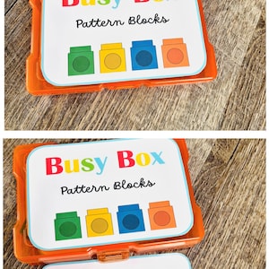 Puede incluir: Una Busy Box de pl&aacute;stico naranja que contiene bloques de patrones. La caja tiene una tarjeta blanca con ilustraciones de bloques coloridos en verde, amarillo, azul y naranja. El texto "Busy Box" est&aacute; en rojo, amarillo y azul.
