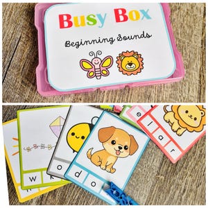 Puede incluir: Una caja de pl&aacute;stico rosa con la etiqueta "Busy Box Beginning Sounds" y tarjetas coloridas con ilustraciones de una mariposa, un le&oacute;n, una cometa, una abeja y un cachorro. Las tarjetas tienen letras e im&aacute;genes para el aprendizaje temprano.