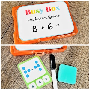 Puede incluir: Un juego de suma Busy Box naranja. El juego incluye tarjetas con problemas de suma, una tarjeta verde con puntos, un marcador negro y un peque&ntilde;o borrador turquesa. La tarjeta superior muestra el problema 8 + 6 =.