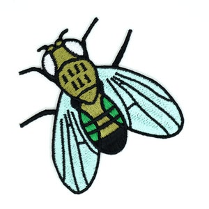 Könnte beinhalten: Ein gestickter Bügel-Aufnäher einer Fliege mit hellblauen Flügeln in Grün, Braun und Schwarz.