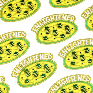 May include: Multiple yellow and green embroidered patches with the word "ENLIGHTENED" in white text. Each patch features a stylized image of a cell with stacks of coins inside.