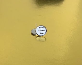 Puede incluir: Un par de pendientes de botón de plata con un disco redondo blanco que dice "Your Picture Here" en texto negro.