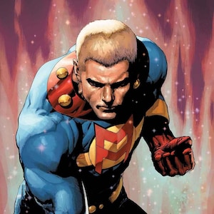 May include: A comic book illustration of a muscular figure with short blonde hair wearing a blue suit with a red collar, gold accents, and a red letter M emblem on the chest. The figure is posed in a dynamic stance against a glowing red background.