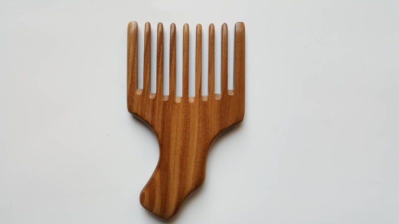 A sandalwood pick comb with a nice curved handle and a row of nine long teeth. This comb has  a natural grain pattern and is one of a kind piece.  Great gift for long hair lovers!