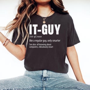 May include: A white ceramic mug with a black handle and the text "But First, Coffee" in a bold, black font. The mug is set against a neutral background, highlighting its simple design.