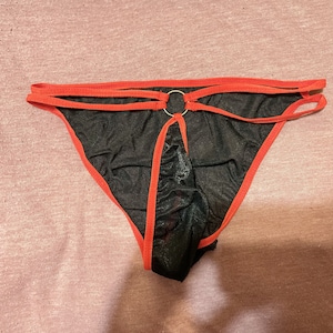 May include: Black mesh underwear with red trim and a silver ring detail.