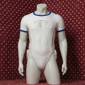 Può includere: Body bianco con rifiniture blu sulle maniche e sullo scollo. Il body presenta uno scollo a forma di buco della serratura sul petto e lacci laterali. Il manichino è esposto su uno sfondo rosso a pois bianchi.