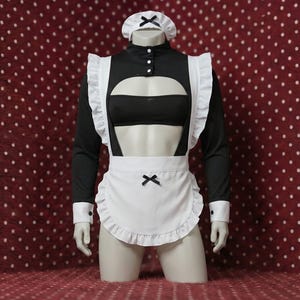 Peut inclure: Un costume de femme de chambre noir et blanc présenté sur un mannequin. Le costume comprend un haut noir avec un tablier blanc, un couvre-chef assorti et un nœud noir. Le tablier a un bord à volants.