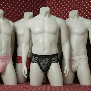 Puede incluir: Cuatro maniquíes exhiben diferentes estilos de ropa interior. Los colores de la ropa interior incluyen rosa, rojo, negro y blanco. La ropa interior tiene un diseño de encaje. Los maniquíes están sobre una superficie roja con lunares blancos.