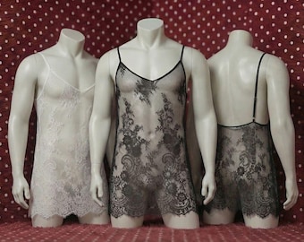 May include: Three mannequins display lingerie. The garments include a white lace chemise, and two black lace pieces. The lingerie features delicate floral patterns and thin straps. The mannequins stand on a red surface with white polka dots.