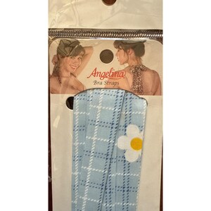 May include: A white ceramic mug with a black handle and the text "But First, Coffee" in a bold, black font. The mug is set against a blurred background, suggesting a cozy setting.