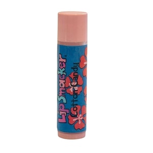 May include: A pink and blue Lip Smacker lip balm with the words "Lip Smacker" and "Cotton Candy" printed on the tube. The tube is decorated with red hibiscus flowers. The cap is pink.