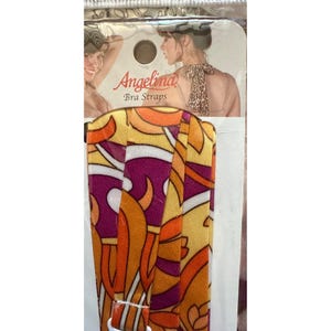 May include: A package of Angelina Bra Straps. The bra straps have a colorful, retro design with orange, yellow, and purple floral patterns. The packaging features a woman wearing a bra and the brand name.