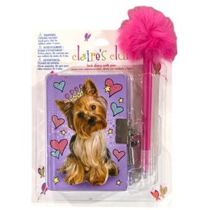 May include: A Claire's Club lock diary with a pen. The purple diary features a Yorkshire Terrier wearing a crown, surrounded by hearts and stars. The set includes a pink pen with a fluffy pom-pom top. The diary has a lock and key.