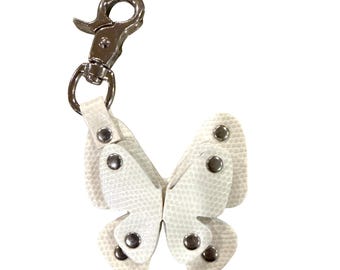 Llavero con dije de mariposa estilo Y2K 2001, de piel sintética blanca con estampado de serpiente y detalles de remaches plateados.