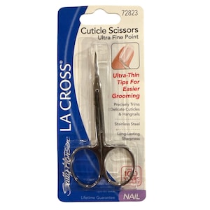 May include: Cuticle scissors with an ultra fine point, packaged in a blue and white card. The stainless steel scissors are designed for easier grooming of cuticles and hangnails. The package includes the text "LA CROSS" and "Sully Hansen".