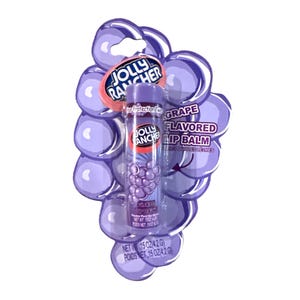 May include: A Jolly Rancher grape-flavored lip balm in a purple package shaped like a bunch of grapes. The lip balm tube is visible, with the Jolly Rancher logo and grape illustration. The package also includes the text "Grape Flavored Lip Balm".