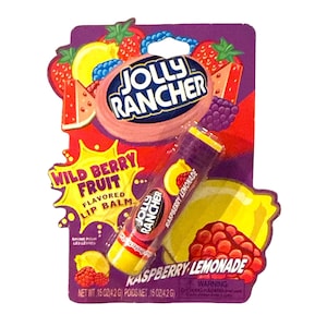 May include: A Jolly Rancher Wild Berry Fruit flavored lip balm in a blister pack. The packaging is purple, red, yellow, and white, with illustrations of fruit. The lip balm tube is purple and yellow, with the words "Raspberry Lemonade".