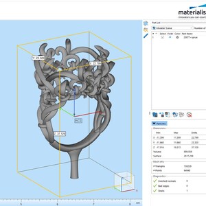 Puede incluir: Un modelo digital 3D gris de un anillo con un dise&ntilde;o intrincado de enredaderas en espiral mostrado en el software Materialise. El cuadro delimitador muestra dimensiones de 22.799 mm por 23.320 mm por 37.129 mm, con el nombre 20077-sprue en la lista.