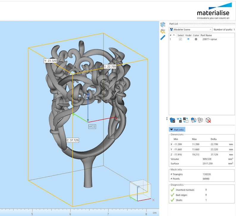 Puede incluir: Un modelo digital 3D gris de un anillo con un dise&ntilde;o intrincado de enredaderas en espiral mostrado en el software Materialise. El cuadro delimitador muestra dimensiones de 22.799 mm por 23.320 mm por 37.129 mm, con el nombre 20077-sprue en la lista.