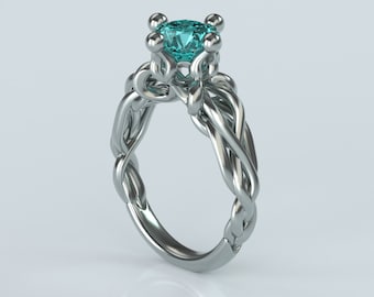 Puede incluir: Un anillo de plata con una piedra preciosa azul engastada en una banda retorcida.