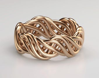 Könnte beinhalten: Ein roségoldener Ring mit einem geflochtenen Design. Der Ring weist mehrere Metallstränge auf, die miteinander verflochten sind, um ein durchgehendes, strukturiertes Muster zu erzeugen. Der Ring wird auf weißem Hintergrund dargestellt.