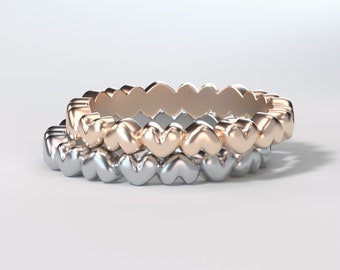Könnte beinhalten: Zwei übereinanderliegende Ringe mit einem herzförmigen Design. Der obere Ring ist roségold und der untere Ring ist silber.