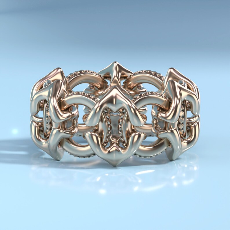 May include: A gold ring with a intricate design featuring a series of connected loops and curves. The ring is set with small diamonds.